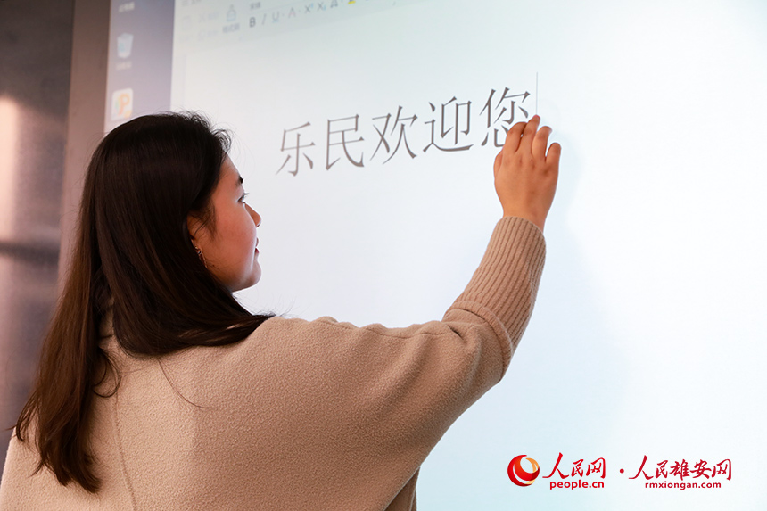 雄安容和樂(lè)民小學(xué)教室安裝有智慧黑板,既可作為普通黑板使用,又可作為電子屏幕。圖為學(xué)校老師正在使用智慧黑板打字。人民網(wǎng) 宋燁文攝