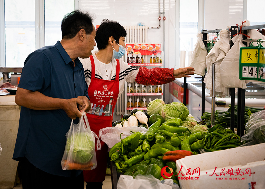 菜店內(nèi)，工作人員正在為顧客提供幫助。出門(mén)就是菜店，吃飯不發(fā)愁，成為容東片區(qū)居民的日常。人民網(wǎng)?宋燁文攝