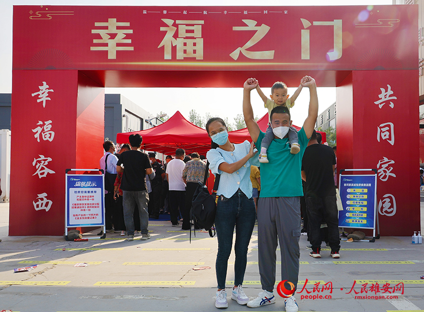 回遷群眾一家三口在“幸福之門”前合影。齊鑫攝