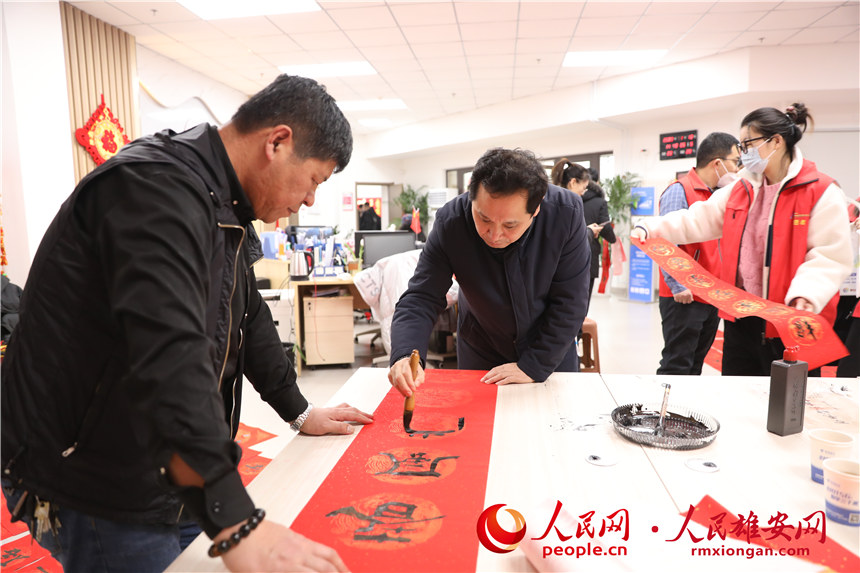 圖為容西片區(qū)愛水社區(qū)組織寫春聯(lián)。人民網(wǎng) 楊華龍攝