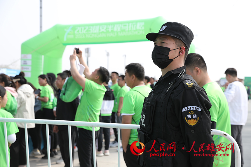 2023雄安半程馬拉松現(xiàn)場，堅(jiān)守崗位的安保人員。人民網(wǎng) 李兆民攝