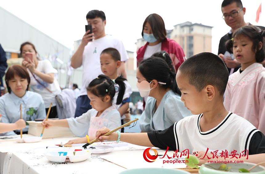 5月31日，雄安容和樂安幼兒園舉辦傳統(tǒng)文化游園活動(dòng)?；顒?dòng)邀請(qǐng)了雄安當(dāng)?shù)胤沁z文化傳承人走進(jìn)幼兒園，與孩子和家長(zhǎng)交流互動(dòng)。通過現(xiàn)場(chǎng)接觸非遺項(xiàng)目，讓孩子們零距離認(rèn)識(shí)非遺、熟悉非遺，感受非遺之美。人民網(wǎng) 李兆民攝