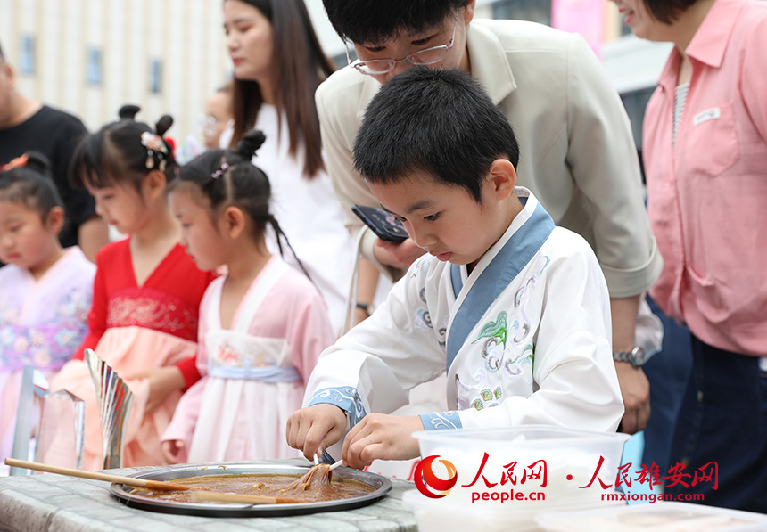 5月31日，雄安容和樂安幼兒園舉辦傳統(tǒng)文化游園活動(dòng)?；顒?dòng)邀請(qǐng)了雄安當(dāng)?shù)胤沁z文化傳承人走進(jìn)幼兒園，與孩子和家長(zhǎng)交流互動(dòng)。通過現(xiàn)場(chǎng)接觸非遺項(xiàng)目，讓孩子們零距離認(rèn)識(shí)非遺、熟悉非遺，感受非遺之美。人民網(wǎng) 李兆民攝