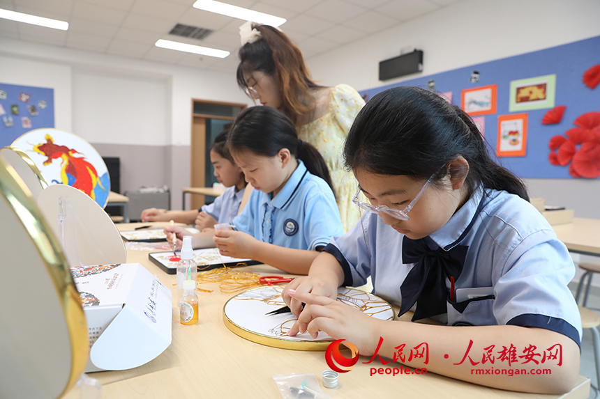 暑假期間，雄安容和樂民小學(xué)老師指導(dǎo)學(xué)生制作中國傳統(tǒng)工藝品——掐絲琺瑯畫，體驗(yàn)非遺藝術(shù)的制作流程。人民網(wǎng) 李兆民攝 (2)