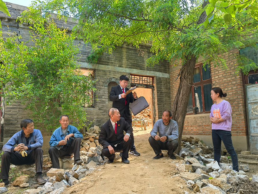 王世廣（左三）與同事對案件進行現(xiàn)場勘驗、調(diào)解。魏振敏攝