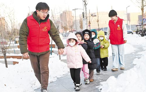 2023年12月20日，容東片區(qū)雙文社區(qū)“雙子星”志愿者護(hù)童小隊(duì)“步行班車”護(hù)送孩子們安全放學(xué)。 河北日?qǐng)?bào)見(jiàn)習(xí)記者 劉光昱攝